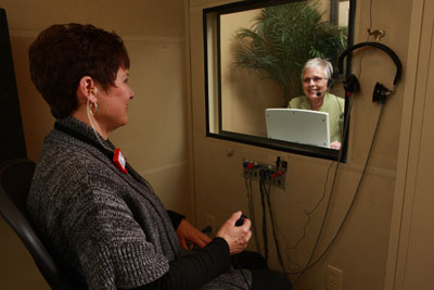 Man having hearing tested in hearing booth